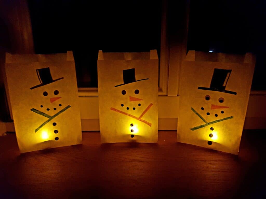 snowman luminaries at night